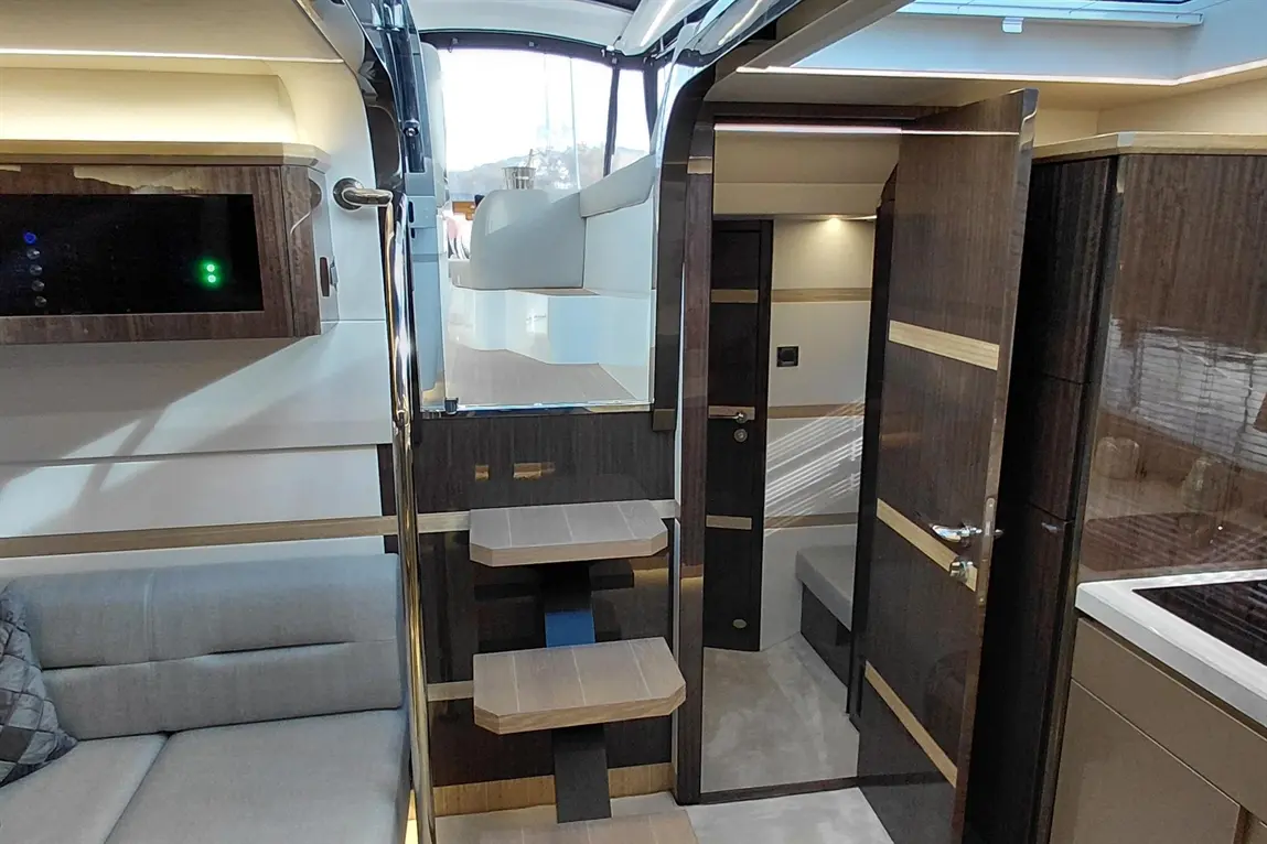 Luxury yacht interior featuring modern décor, sleek stairs, and a comfortable lounge area with a light grey sofa.